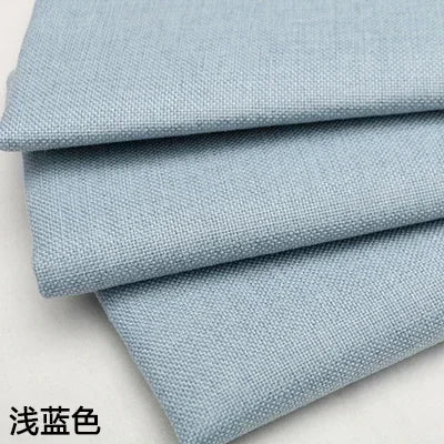 Stack of light blue coarse linen and cotton fabric rolls