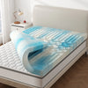 A memory foam mattress topper with cooling gel is displayed on a bed, featuring a blue and white wave pattern.