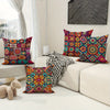 A collection of colorful boho chic mandala plaid pillow covers displayed on a white sofa.