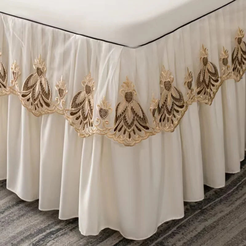 Three cream embroidered cotton bedspreads and pillowcases displayed in a draped style.
