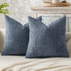 A dark blue textured chenille pillow cover with a minimalist design resting on a light-colored surface.