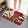 A geometric patchwork floor mat featuring shades of maroon, beige, and brown patterns.