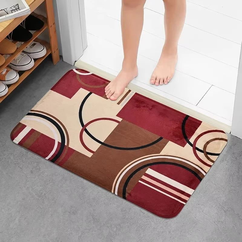 A geometric patchwork floor mat featuring shades of maroon, beige, and brown patterns.