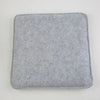 A square, gray needle felting mat pad with rounded edges.