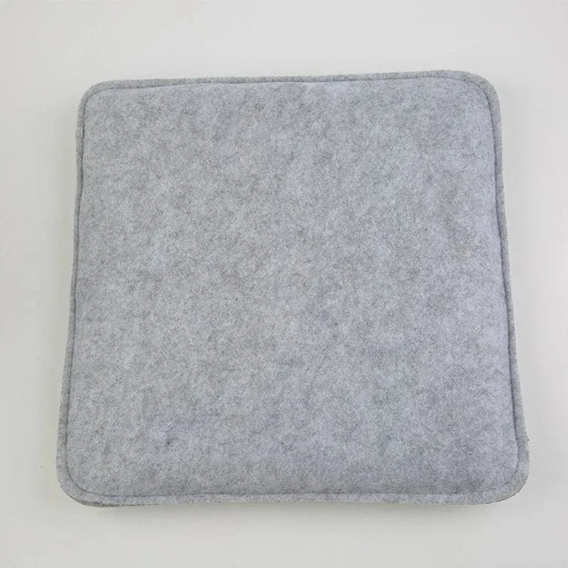 A square, gray needle felting mat pad with rounded edges.