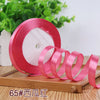 Roll of pink satin ribbon used for crafting or decoration
