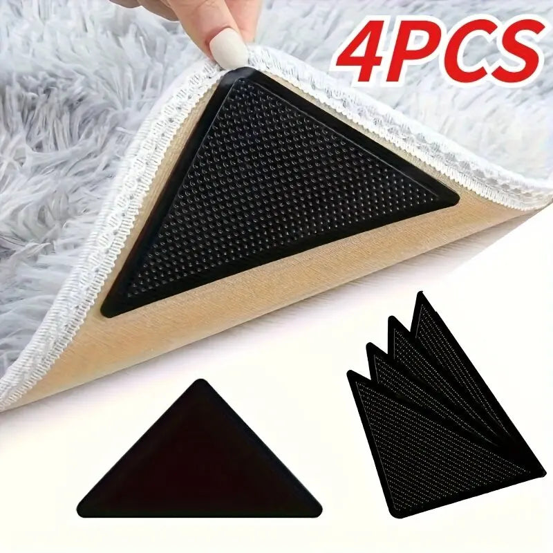 Four black non-slip carpet grippers shown on a white fuzzy surface.
