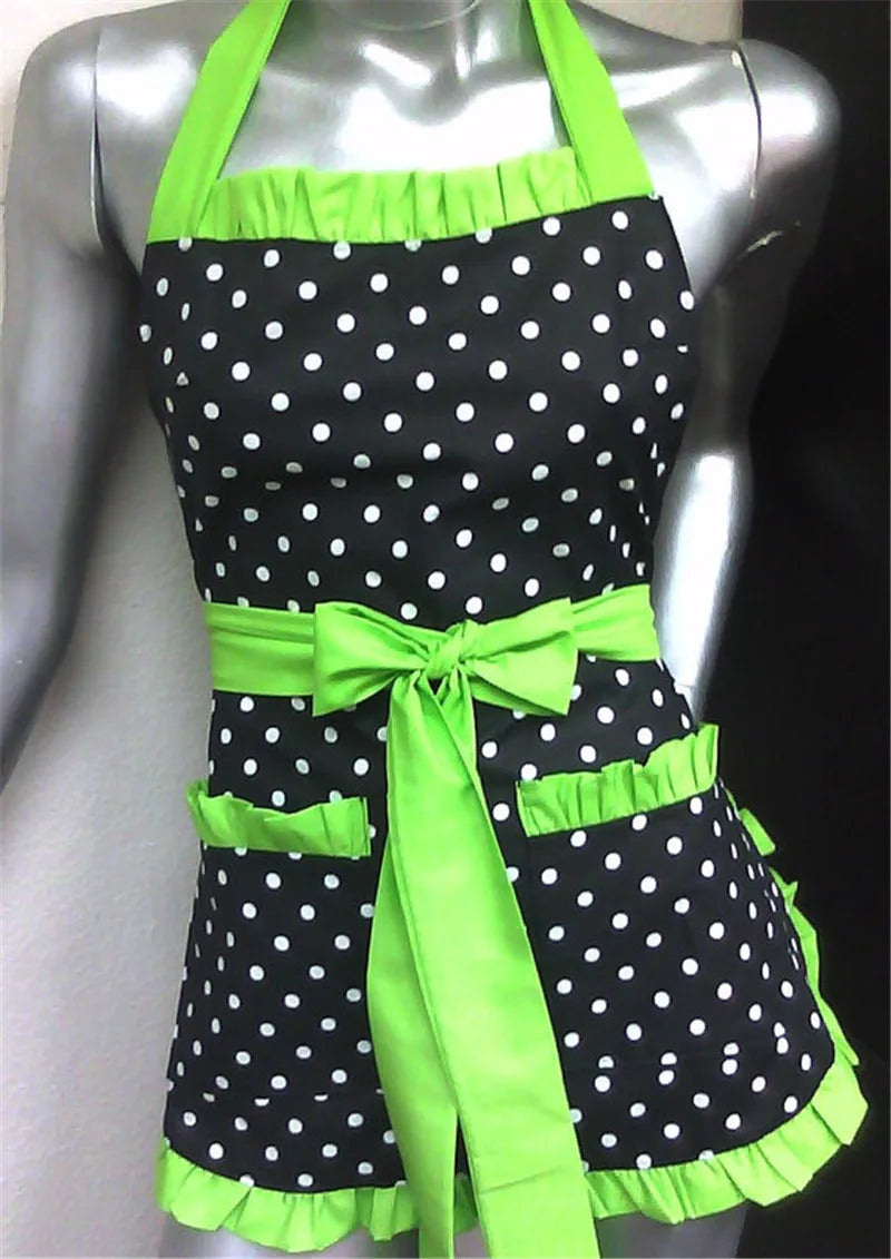 A black polka dot apron with bright lime green trim and ruffle details displayed on a mannequin.
