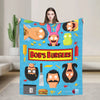 A blue throw blanket featuring various cartoon characters and food themes like burgers and vegetables.