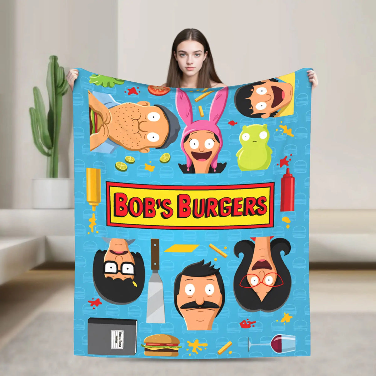 A blue throw blanket featuring various cartoon characters and food themes like burgers and vegetables.