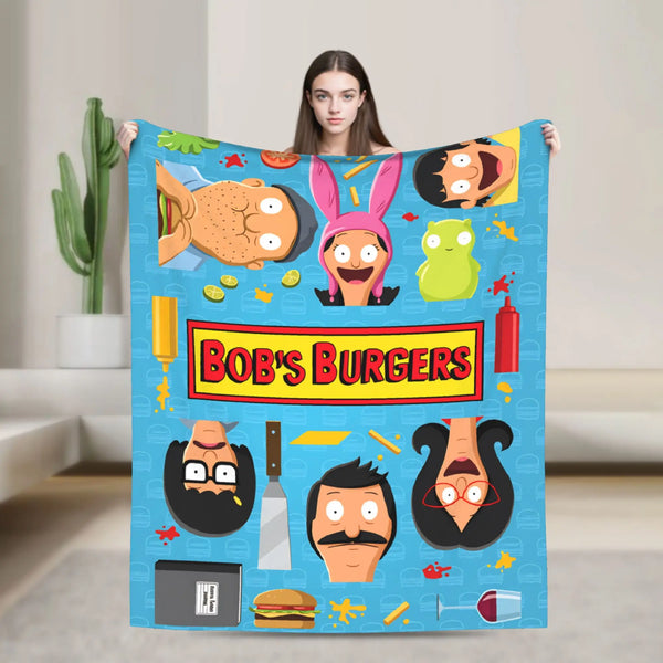 A blue throw blanket featuring various cartoon characters and food themes like burgers and vegetables.