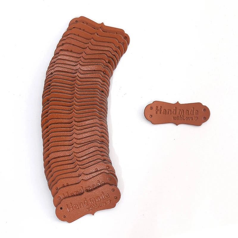 A stack of 50 PU leather embossed tags in a brown color used for handmade crafting.