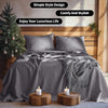 A gray French stone washed linen bedding set featuring pillows and a duvet on a wooden bed with a Christmas tree in the backg