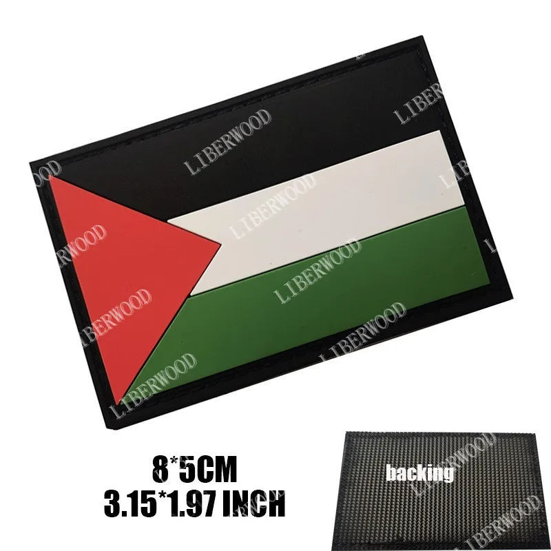 A black rectangular patch featuring the Palestinian flag design with red, white, and green stripes.
