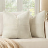 A set of four neutral corduroy throw pillow covers with a vertical ribbed and patchwork design on a light sofa.