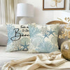 A decorative pillow cover featuring a light blue and white pattern of oceanic coral and starfish on a neutral fabric.