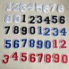 A collection of white, black, and blue number patches for apparel, numbered 1 through 90.