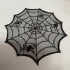Black lace table runner placemat featuring a large spider web design