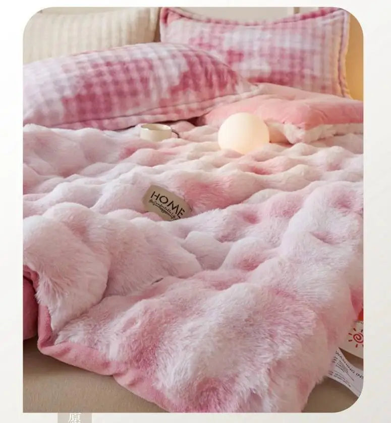 A pink and white plaid plush rabbit quilt comforter with a fluffy texture is displayed on a bed.