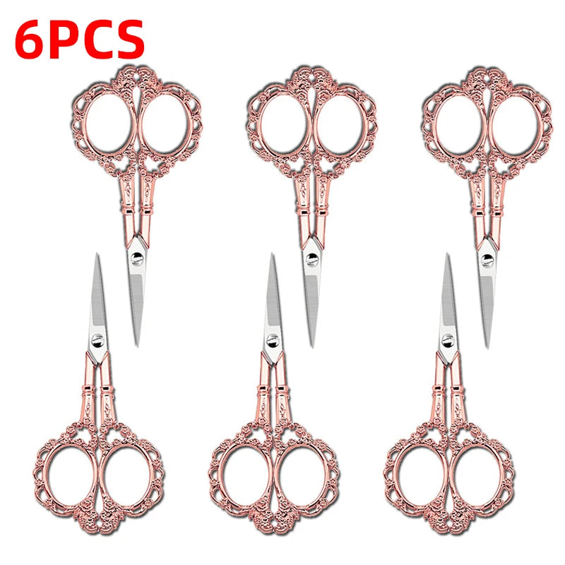 Six pairs of rose gold colored crafting scissors with decorative scrollwork designs