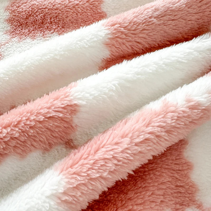 A close-up of a soft flannel panda fleece blanket featuring a white and dusty rose mottled pattern.