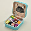 A light blue leather sewing box containing a complete hand sewing kit with needles and various colored threads.