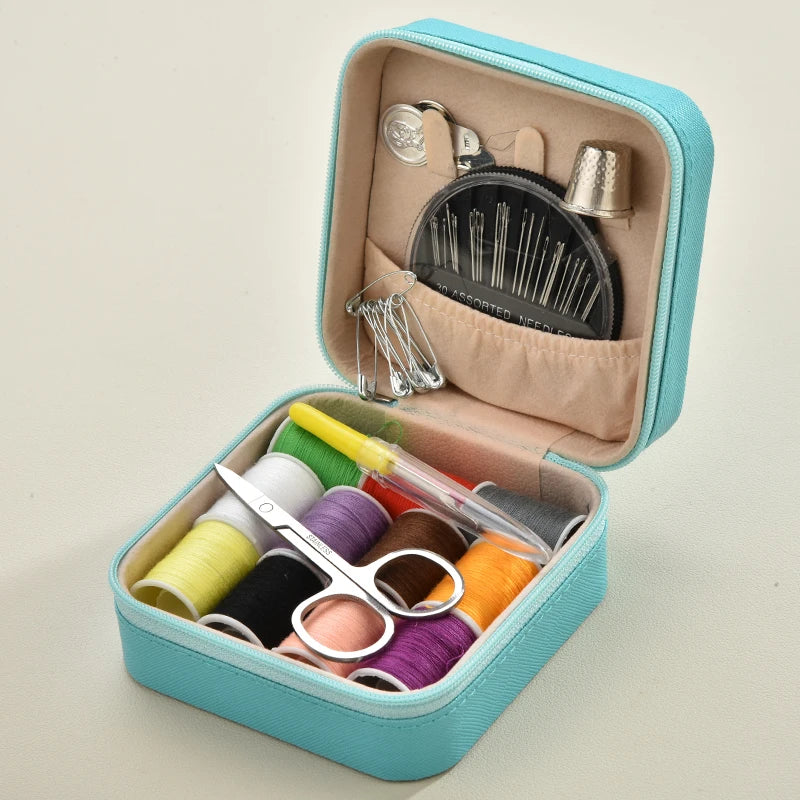 A light blue leather sewing box containing a complete hand sewing kit with needles and various colored threads.