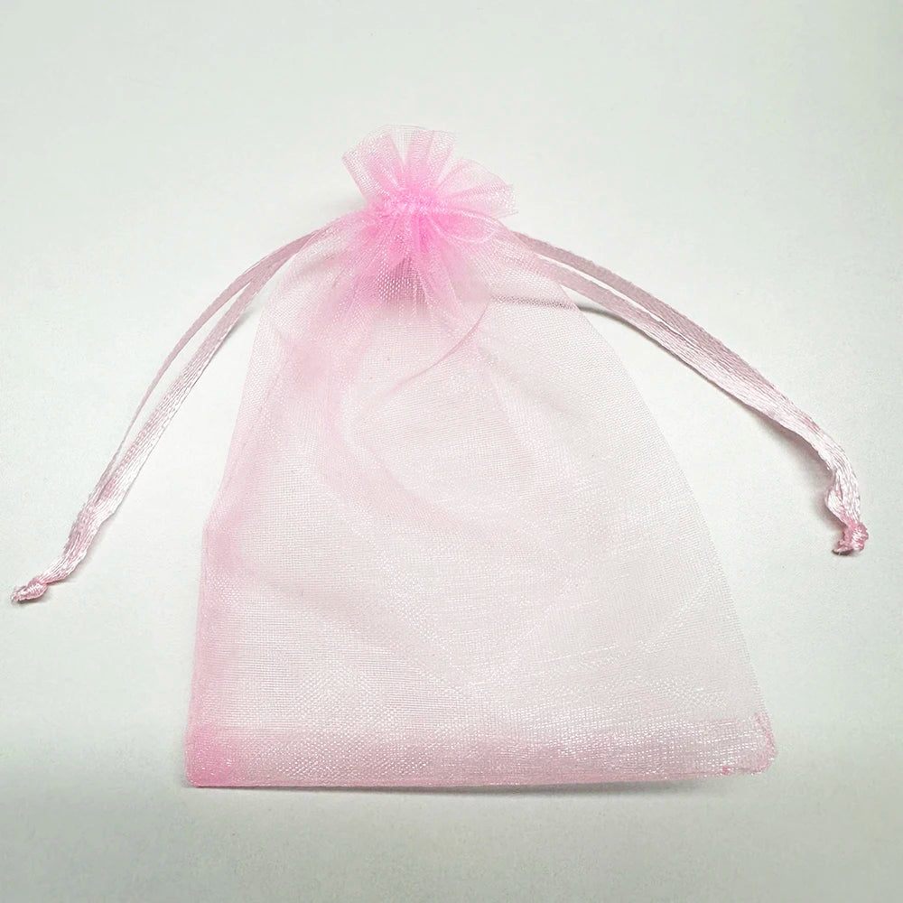 Pink organza gift bags tied with a sheer pink ribbon for bulk jewelry and candy storage