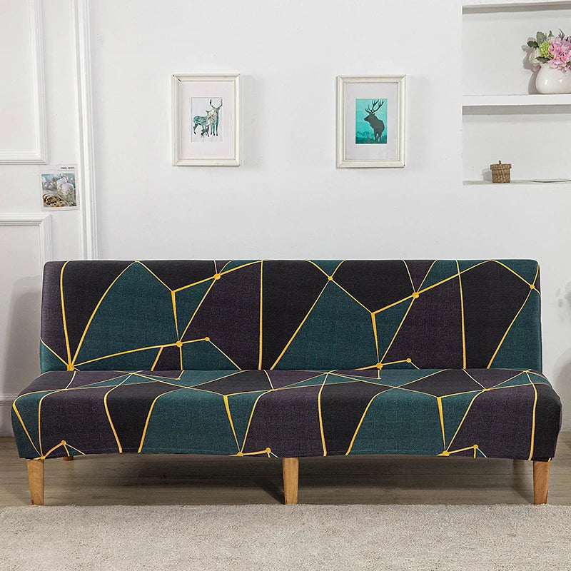 A dark teal and black geometric print spandex slipcover on a sofa bed with framed artwork above it.