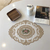 An elegant oval lace embroidered coaster set featuring floral designs on a white background.