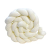 A tightly hand-knotted white mat or coil made of thick, creamy white fibers.