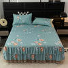 Light blue floral bed skirt protecting a mattress on a dark bed frame.