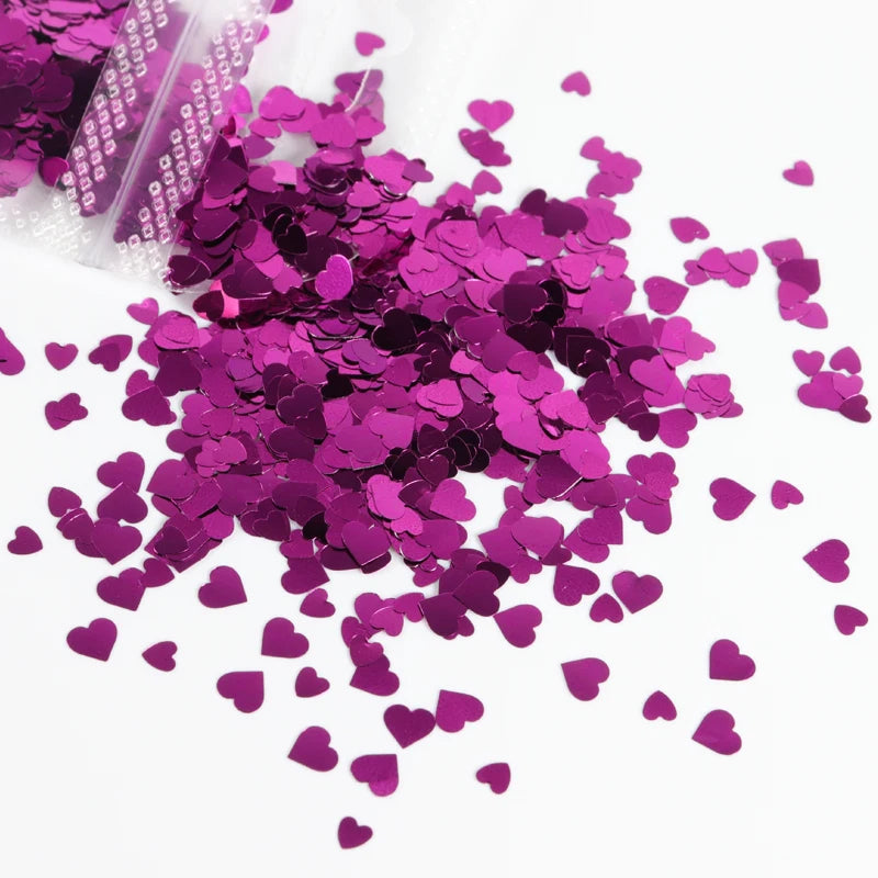 A pile of sparkly magenta heart-shaped resin glitter filler for epoxy art.