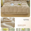 A beige solid cotton bed linen set featuring a duvet, pillows, and decorative elements on a light wood surface.
