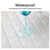 A glass of blue liquid is dripping onto a white quilted fabric surface, demonstrating the waterproof property.