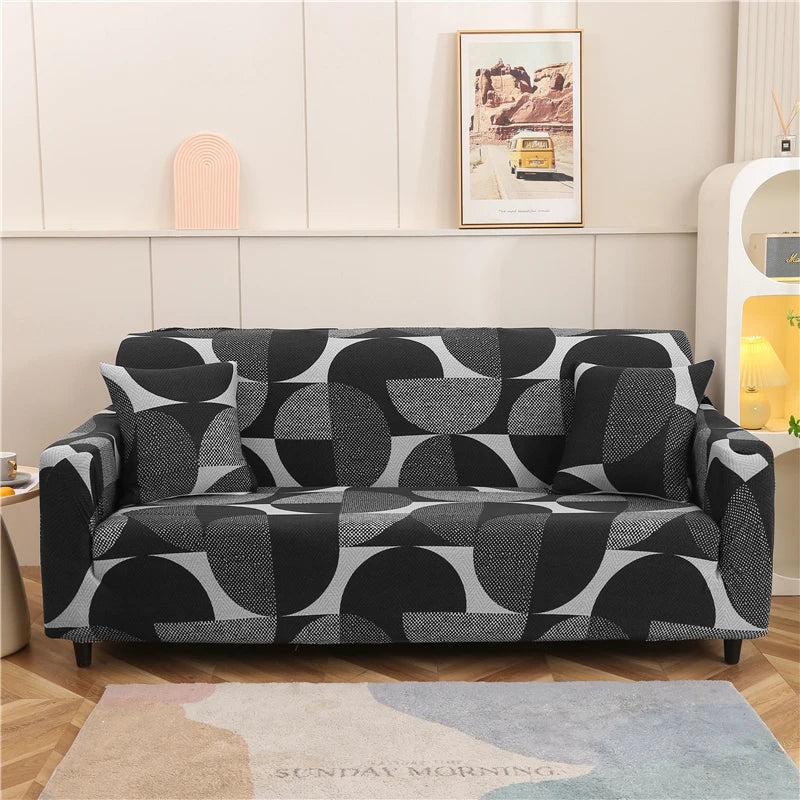 A black and white patterned stretch floral elastic sofa cover displayed on a light wood floor.