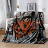 A dark flannel blanket featuring a collage of black and white photographs of musicians and performers.