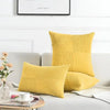 A collection of yellow retro corduroy patchwork pillow covers arranged on a light gray sofa.