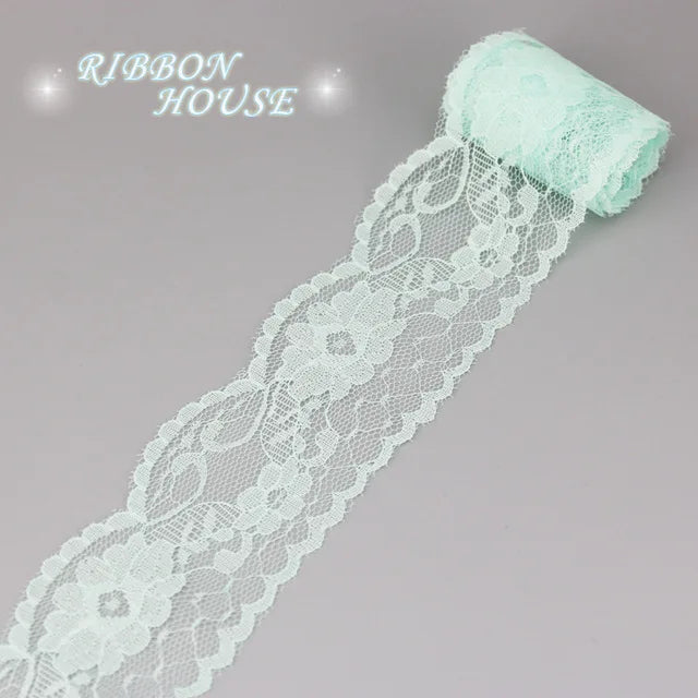 A roll of light mint green decorative lace ribbon for crafting or decoration.