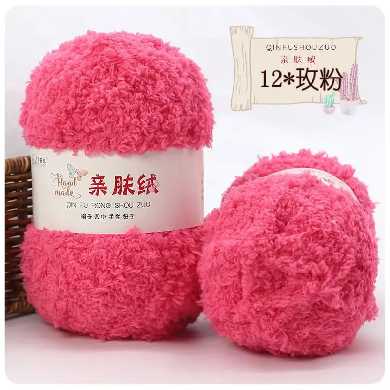 A pink ball of soft coral velvet yarn labeled as QINFUSHOUZUO 12 pack for crafting.