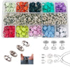 A collection of colorful metal sewing buttons and various tools for crafting and sewing.