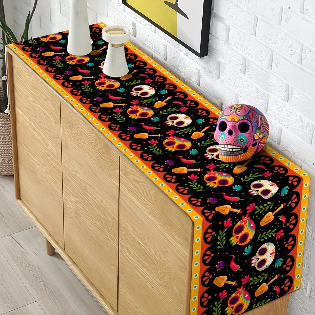 A vibrant Day of the Dead sugar skull linen table runner featuring colorful floral patterns and skulls on a wooden cabinet.