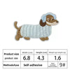 A light blue and brown embroidered patch of a dog lying down.
