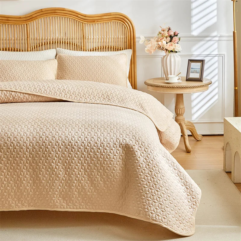 A beige plaid quilt set is displayed on a queen bed with a wooden headboard and natural light.