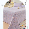 A lilac floral quilted bedspread draped over a bed, emphasizing soft texture and light.