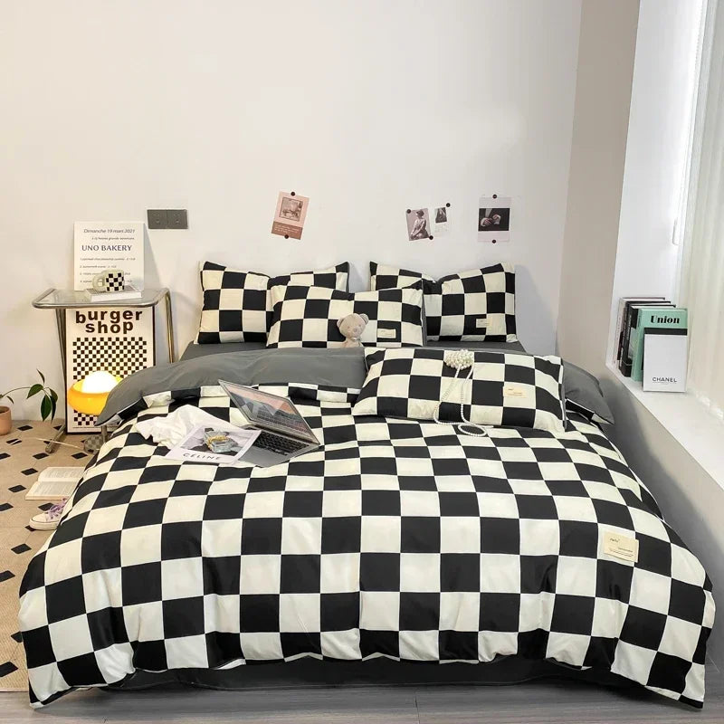 A black and white plaid duvet cover set displayed on a bed with decorative wall art.