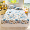 A floral print fitted bed sheet with blue and beige flowers is displayed on a white bed.