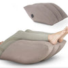 A beige inflatable leg elevation pillow is shown supporting a person's lower leg and foot.