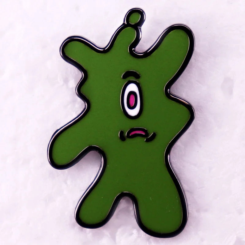A green Plankton enamel brooch with a surprised expression and pink eye details.