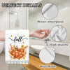 A white kitchen towel with a fall pumpkin print demonstrating water absorption and high-quality self-made material.